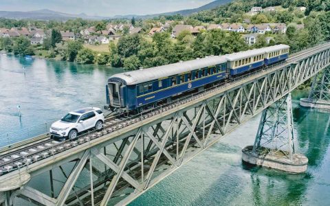 So etwas sieht man auch nicht alle Tage: Ein Land Rover Discovery Sport fährt über eine Eisenbahnbrücke, die den Rhein überspannt, und zieht dabei drei Waggons mit einem Gesamtgewicht von 100 Tonnen hinter sich her.